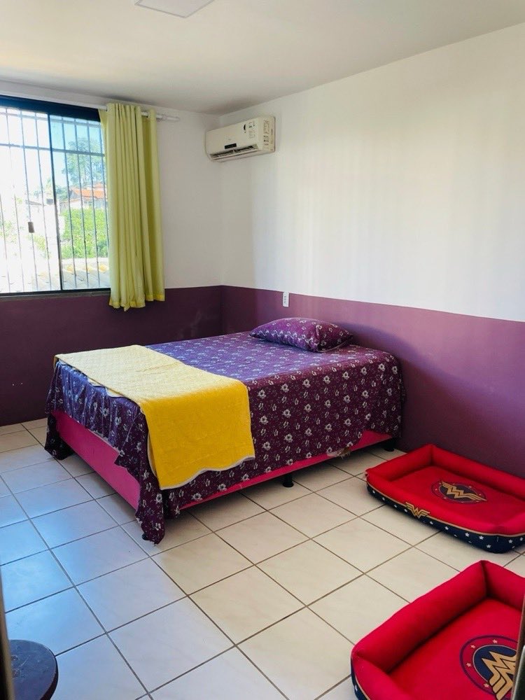 Quarto climatizado do hotel, com cama, ar-condicionado e caminhas