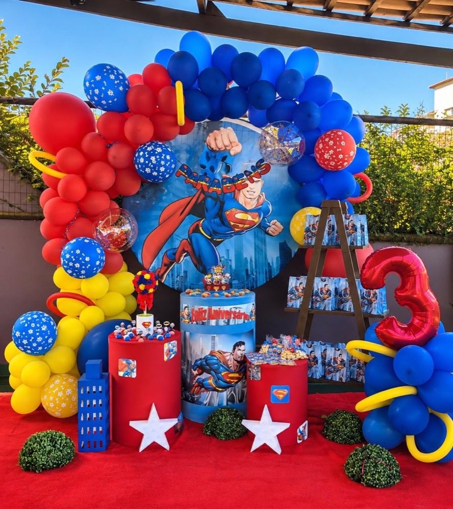 Decoração de aniversário com tema de super-herói, arco de balões e mesa temática
